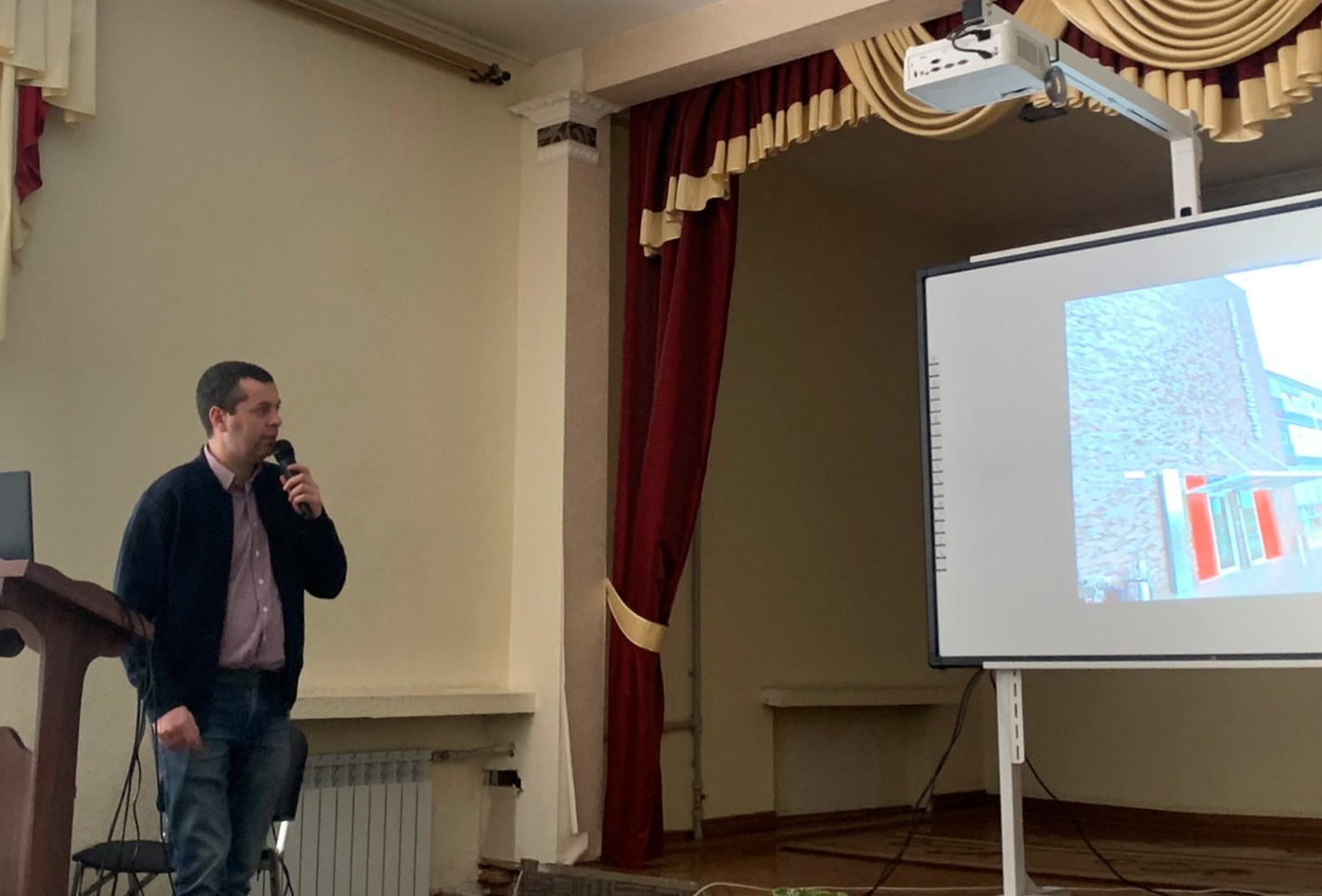 Іван Рудакевич показує презентацію поїздок студентів-туристів